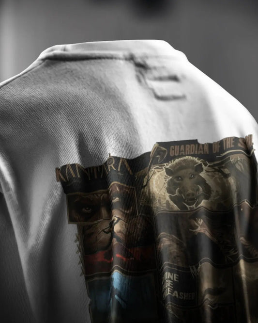 “Detailed shot of the graphic print on the back of a white Kantara-themed t-shirt, featuring a wild boar and character artwork with the text ‘Guardian of the Soil’.”